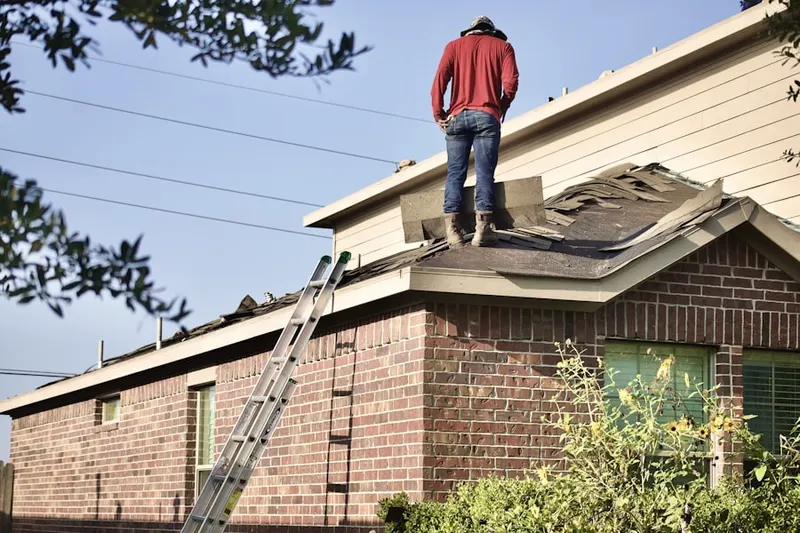 Professional roofer working on a residential roof in Andree